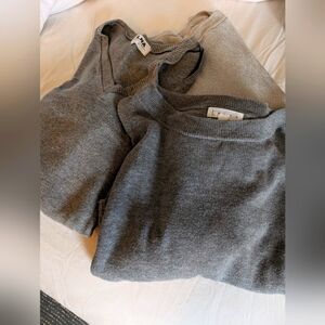Three gray sweaters, two with cutout-details
